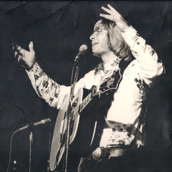 John Denver Джон Денвер поёт на сцене с гитарой